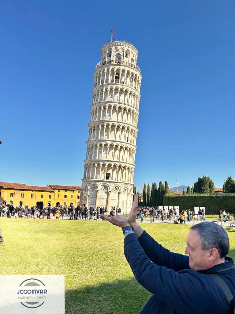 Juan Carlos Gómez Vargas posando para una foto frente a la Torre Inclinada de Pisa, sosteniéndola con ambas manos.